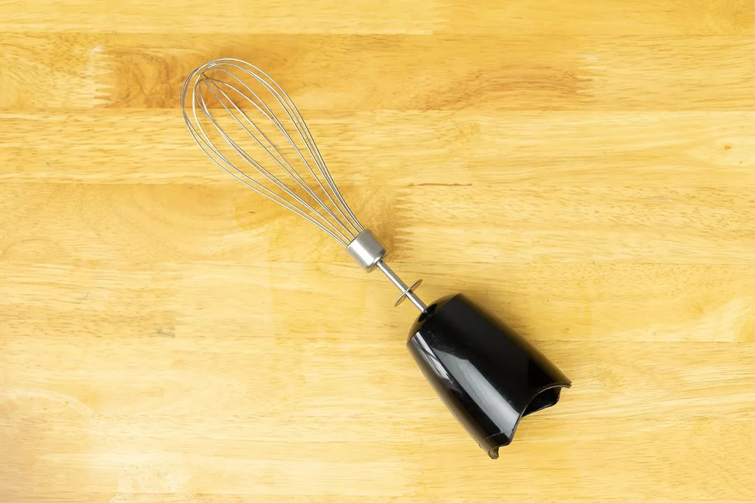 The whisk attachment of the Braun MultiQuick-5 lies flat on a yellow table. 