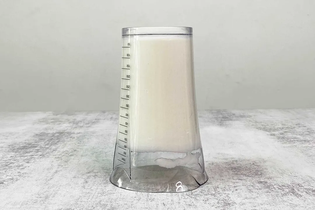 Putting the 24-oz plastic beaker containing testing beaten egg-white upside down on the gray table.