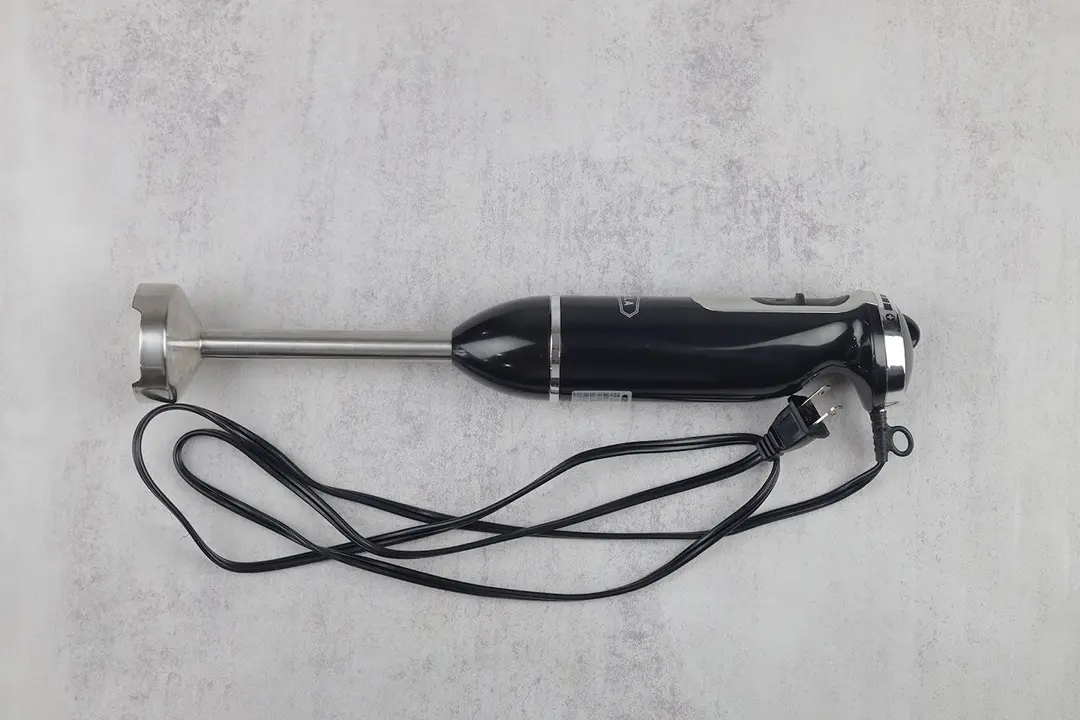 The BELLA 10-Speed  Immersion Blender on a gray table with its power cord rolled up next to it.