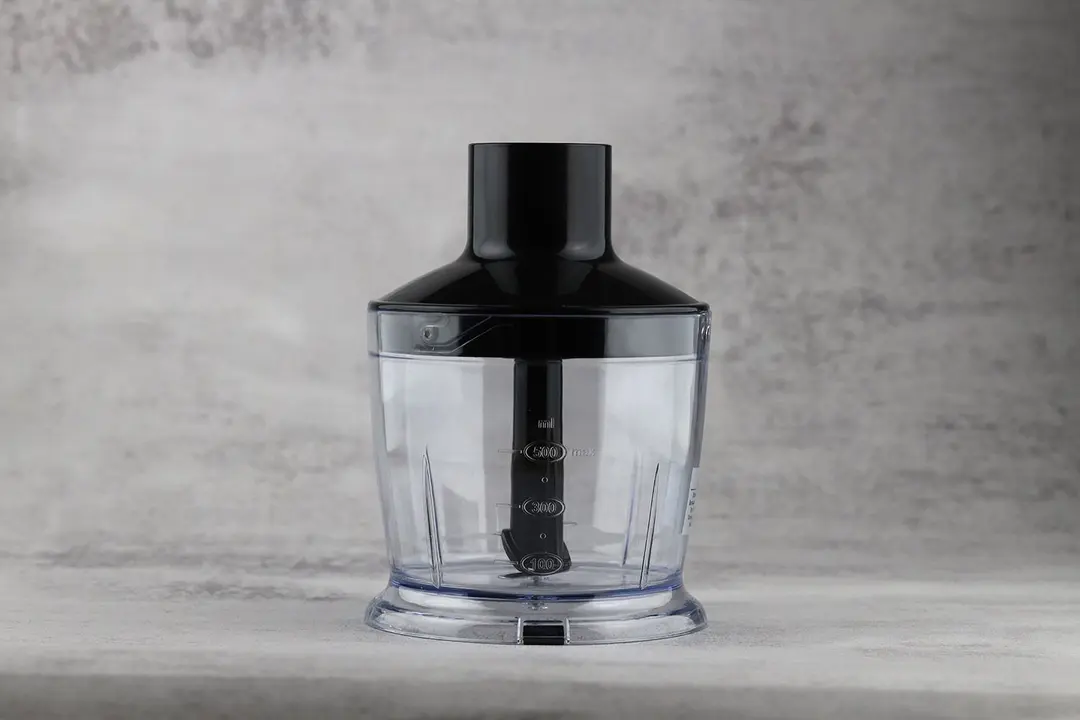 The KOIOS 4-in-1 Immersion Blender Food Processor standing on a gray table.