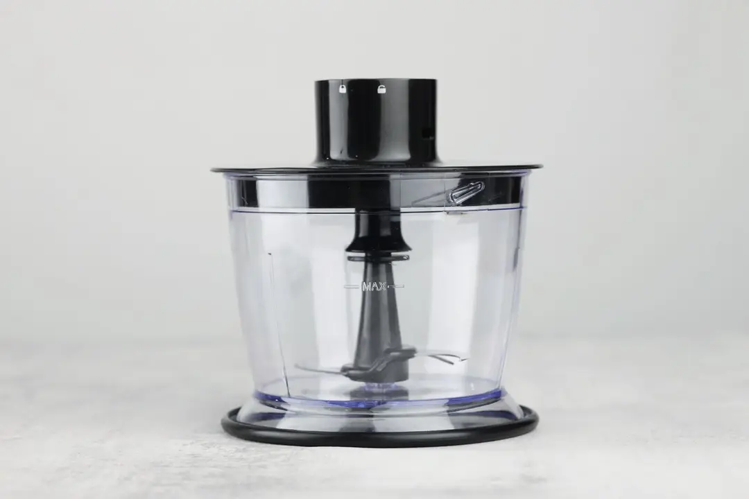A food processor attachment of the Hamilton Beach blender standing on a gray table.