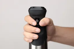 A close-up of the Vitamix’s handle being held from a front view.