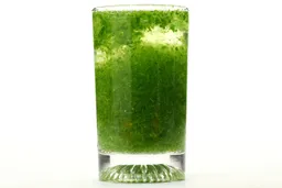 A glass of water with fibrous green pulp produced by the KOIOS Bullet Personal Blender sinking from its top to bottom.