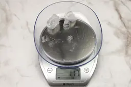 The amount of unblended ice cubes (1.17 oz) of the Ninja Fit QB3001SS single-serve blender displayed on a scale’s screen. 