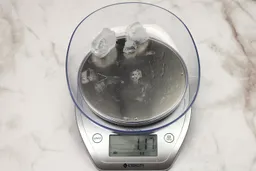 The amount of unblended ice cubes (1.17 oz) of the Ninja Fit QB3001SS single-serve blender displayed on a scale’s screen. 
