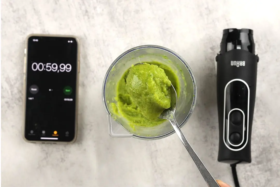 Scooping a spoon of smoothie from the plastic beaker to check its texture after the Braun MultiQuick-5 Vario Hand Blender had completed the test in 59,99 seconds.