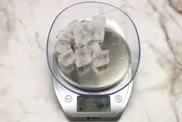 The amount of unblended ice cubes (4.61 oz) of the KOIOS Bullet single-serve blender displayed on a scale’s screen.
