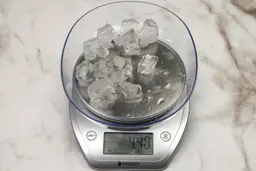 The amount of unblended ice cubes (4.48 oz) of the Hamilton Beach single-serve blender displayed on a scale’s screen.