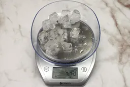 The amount of unblended ice cubes (4.48 oz) of the Hamilton Beach single-serve blender displayed on a scale’s screen.