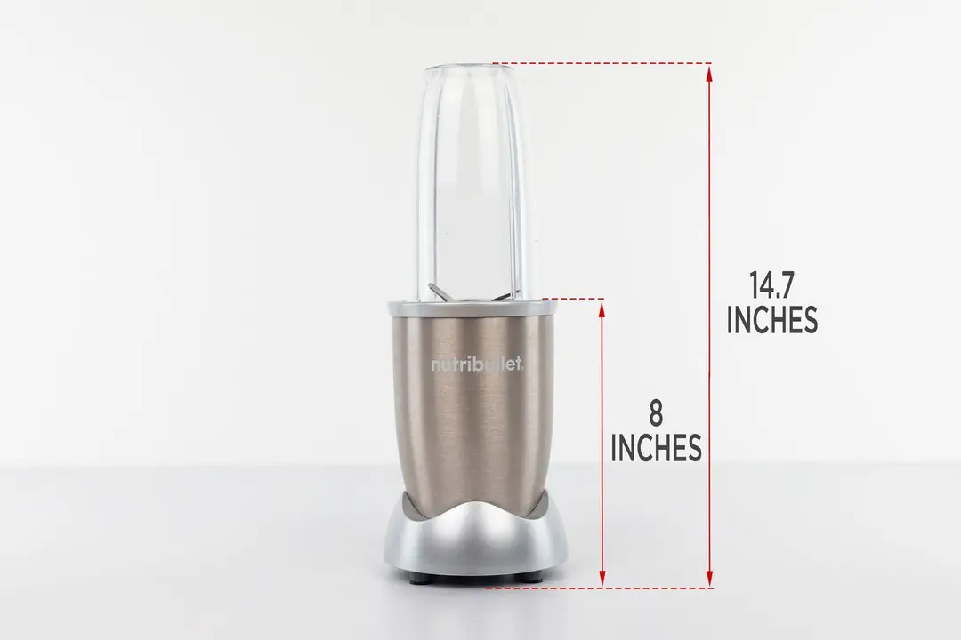 The NutriBullet Pro 900-watt personal blender standing on a gray table, with the length of its motor base being noted to the side as 8 inches, and the total length of the unit as 14.7 inches.