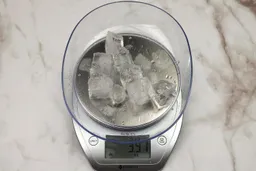 The amount of unblended ice cubes (3.91 oz) of the Oster Myblend single-serve blender displayed on a scale’s screen.