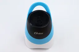 The motor base of the Oster personal blender standing on a white table.