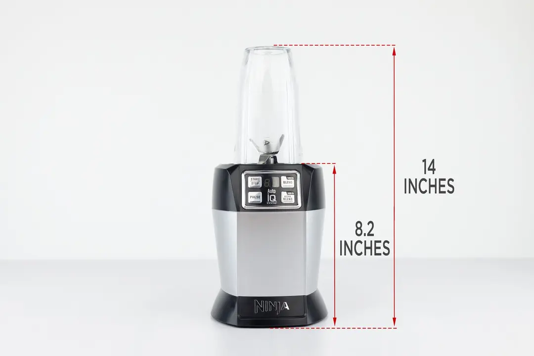 The Ninja Nutri 1000-watt personal blender standing on a gray table, with the length of its motor base being noted to the side as 8.2 inches, and the total length of the unit as 14 inches.