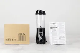 The Hamilton Beach Personal Blender standing on a table with its user’s manual and paper carton box by its sides.