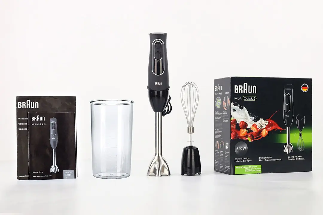 Unboxing the The Braun MultiQuick-5 hand blender, from left to right: user manuals, plastic beaker, the Braun MultiQuick-5 with its motor body and blending shaft attached, whisk attachment, and a paper carton box.
