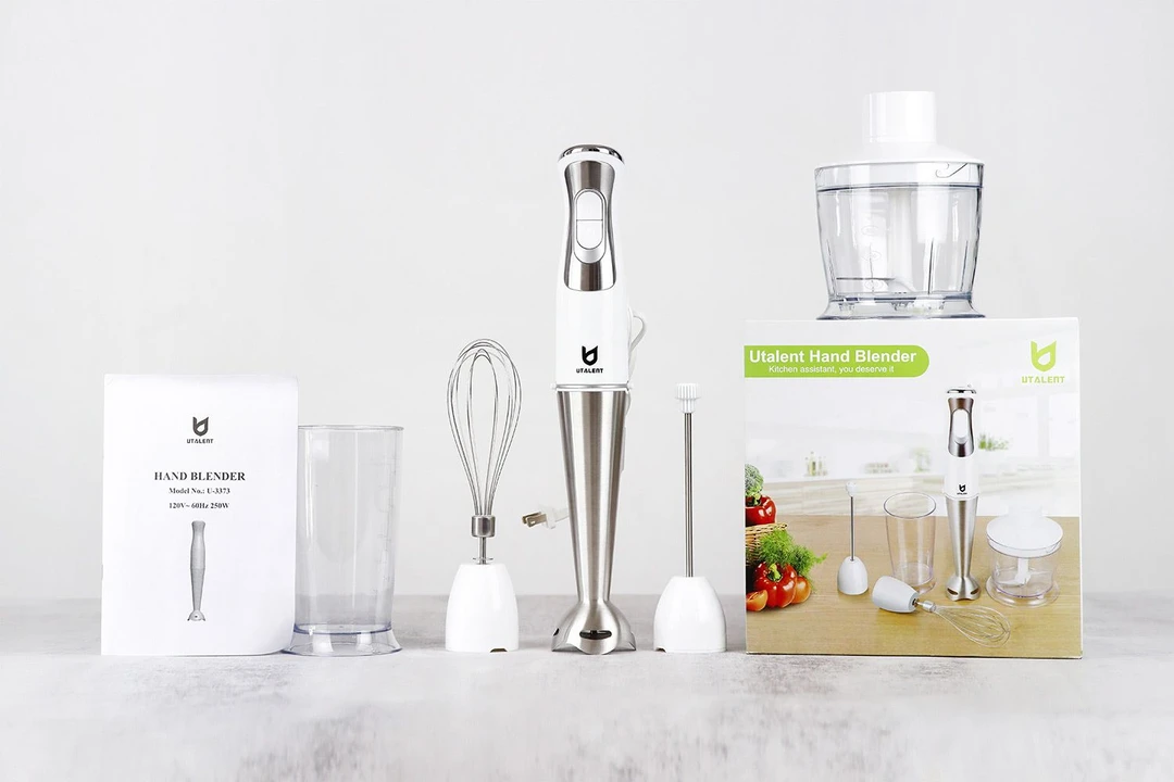 The UTALENT Immersion Blender set includes a user’s manual, a plastic beaker, a whisk attachment, the UTALENT blending wand with its motor body attached, a milk frother attachment, a food processor, and a paper carton box.