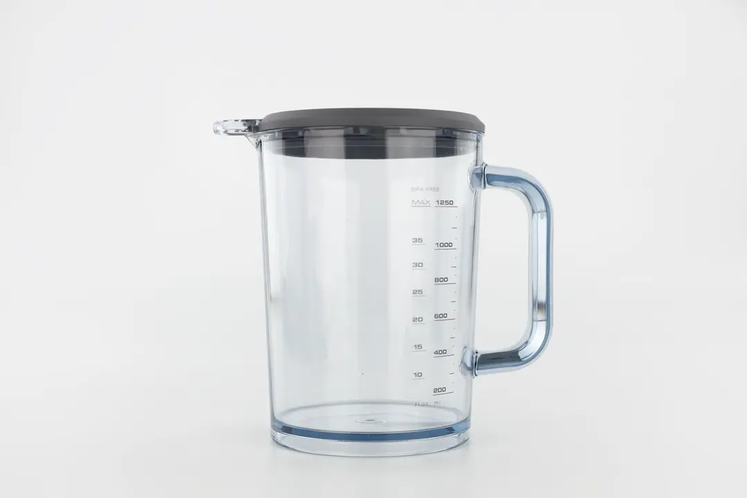 The Breville’s 1250 ml plastic beaker standing on a white table with its lid attached. 