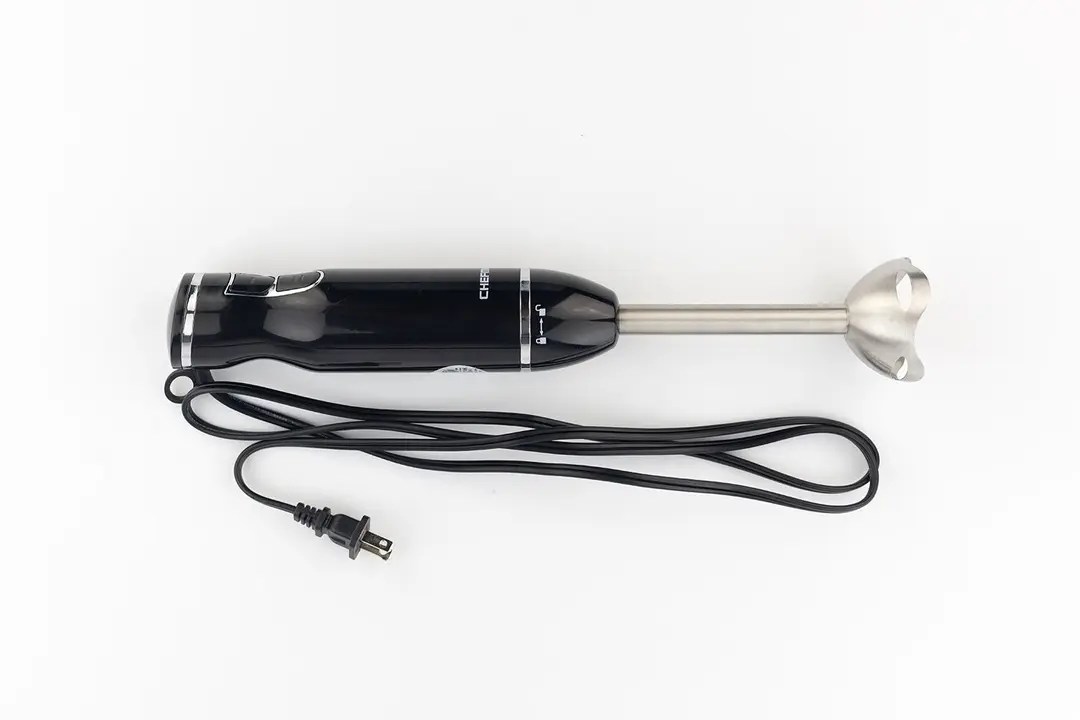 The Chefman Immersion Blender on a white table with its power cord that features a 2-prong plug rolled up next to it.