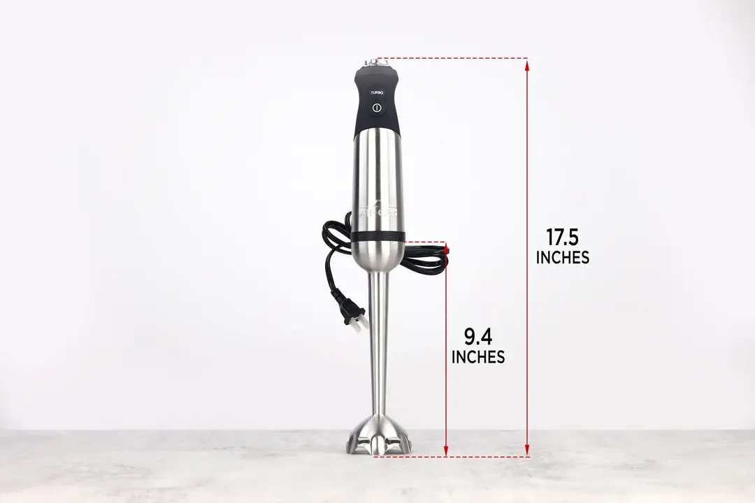 The All-Clad immersion blender standing on top of its blending shaft on a gray table, with the length of the blending shaft being noted to the side as 9.4 inches, and the total length of the unit as 17.5 inches.