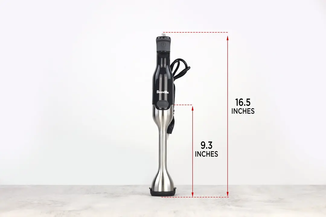 The Breville immersion blender standing on top of its blending shaft on a gray table, with the length of the blending shaft being noted to the side as 9.3 inches, and the total length of the unit as 16.5 inches. 
