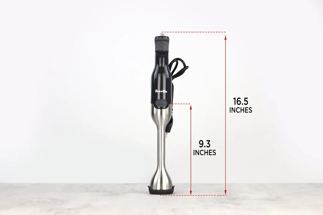 The Breville immersion blender standing on top of its blending shaft on a gray table, with the length of the blending shaft being noted to the side as 9.3 inches, and the total length of the unit as 16.5 inches. 