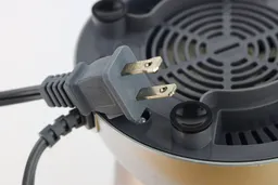 A close-up of the power plug, silicone feet, and cooling fan in the underside of the NutriBullet’s motor base.