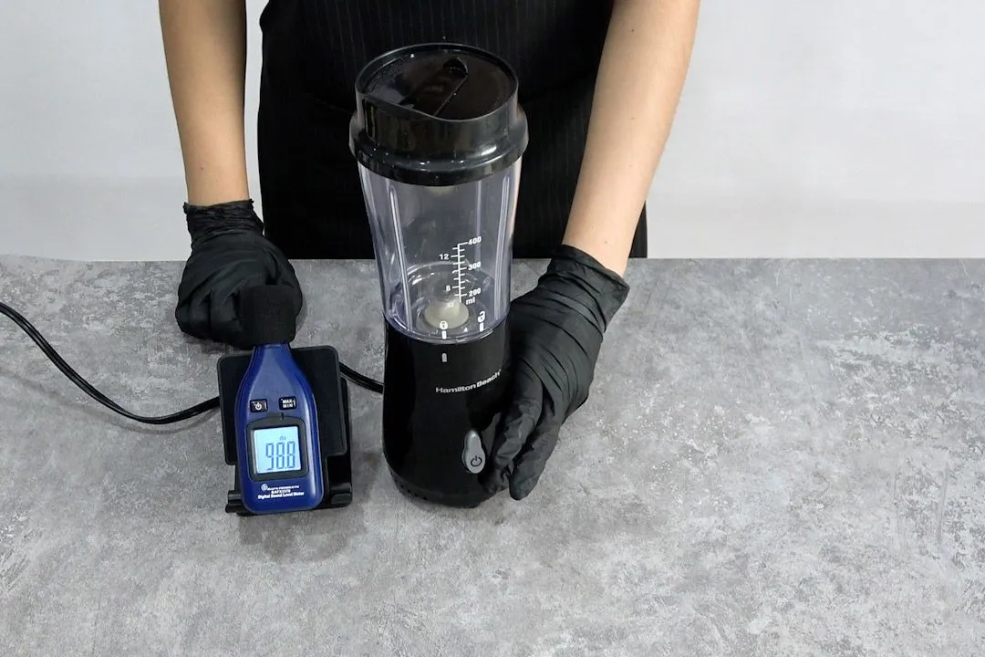 Someone is measuring the noise level of the Hamilton Beach personal blender with the noise meter (98.8 dB).