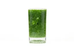 A glass of water combined with fibrous greens pulp produced by the iCucina Single-Serve Blender.