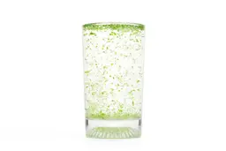 A glass of water and fibrous greens pulp produced by the La Reveuse Single-Serve Blender.