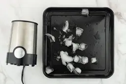 A black tray of crushed ice produced by the BELLA being on a table.