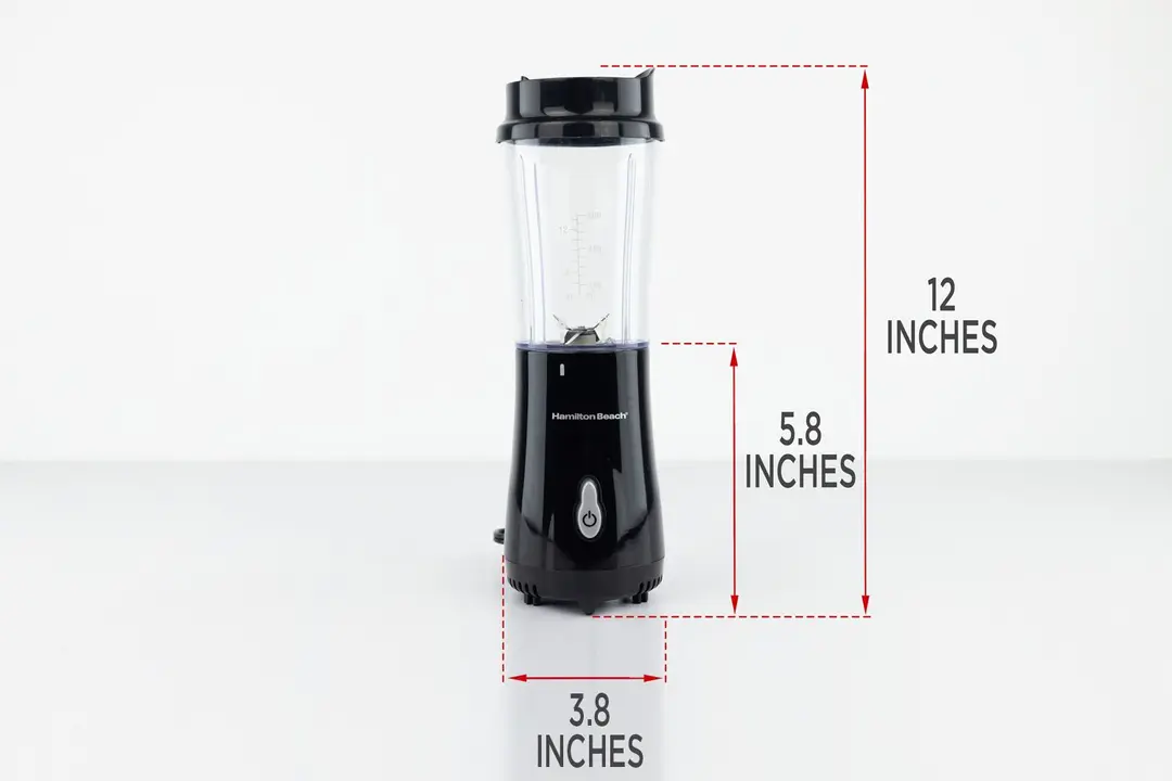 The Hamilton Beach 51101AV Personal Blender standing on a gray table, with the length of its motor base being noted to the side as 5.8 inches, and the total length and width of the unit as 12 inches and 3.8 inches, respectively. 