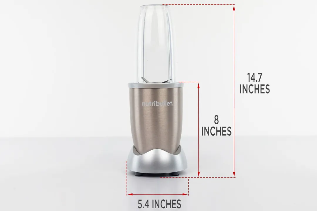 The NutriBullet Pro 900-watt personal blender standing on a gray table, with the length of its motor base being noted to the side as 8 inches, and the total length and width of the unit as 14.7 inches and 5.4 inches, respectively.