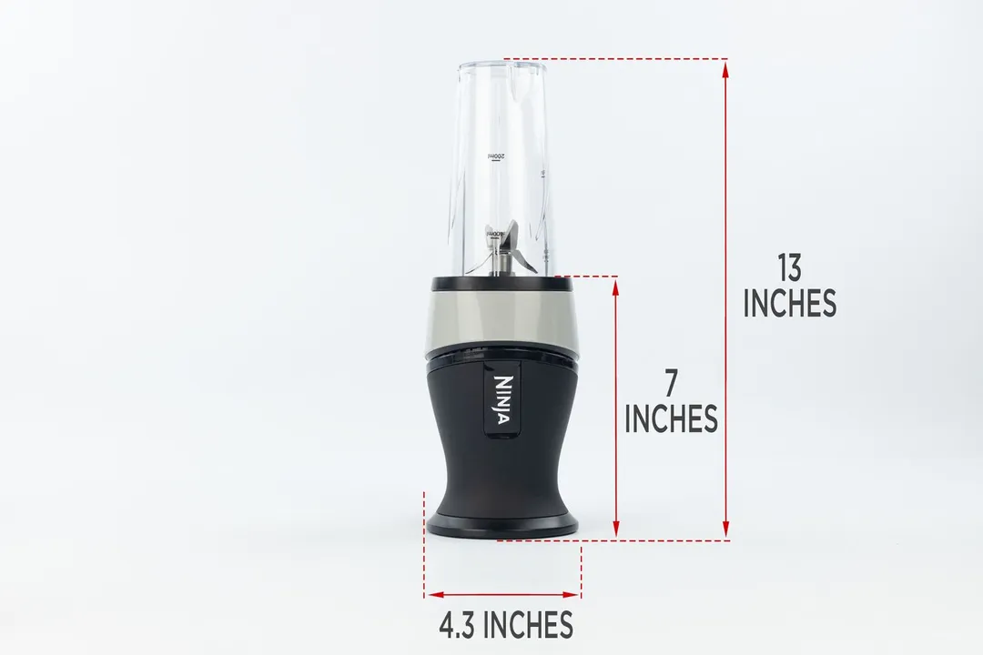 The Ninja Fit Personal Blender standing on a gray table, with the length of its motor base being noted to the side as 7 inches, and the total length and width of the unit as 13 inches and 4.3 inches, respectively.