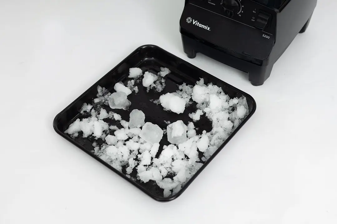 A black tray of fine ice produced by the NutriBullet on a table.