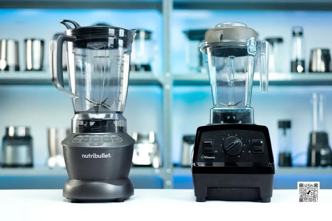 The NutriBullet and Vitamix E310 stand side by side on a countertop. In the backdrop, various models of blenders occupy the shelves.