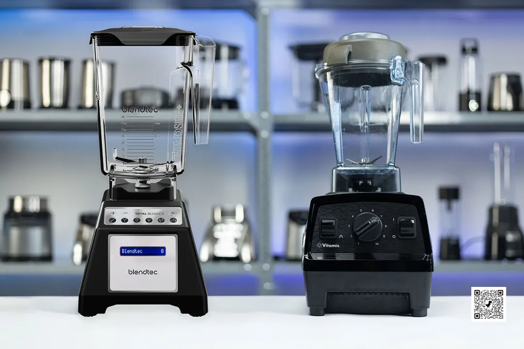 The Blendtec and Vitamix E310 stand side by side on a countertop. In the backdrop, various models of blenders occupy the shelves.