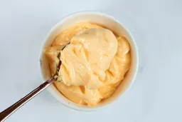 Scooping a spoon of mayonnaise made by the Peach Street immersion blender.