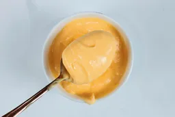 Scooping a spoon of mayonnaise made by the Braun MQ7035X immersion blender.