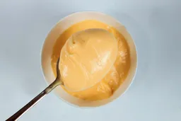 Scooping a spoon of mayonnaise made by the Braun MQ7035X immersion blender.