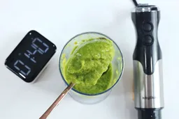 Scooping a spoon of frozen fruit smoothie from a full batch in a plastic beaker made by the Keylitos 5-in-1 immersion blender in 1 minute 40 seconds.