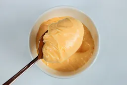 Scooping a spoon of mayonnaise made by the Keylitos 5-in-1 immersion blender.