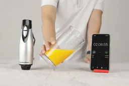 Blender and beaker containing mayonnaise next to smartphone timer