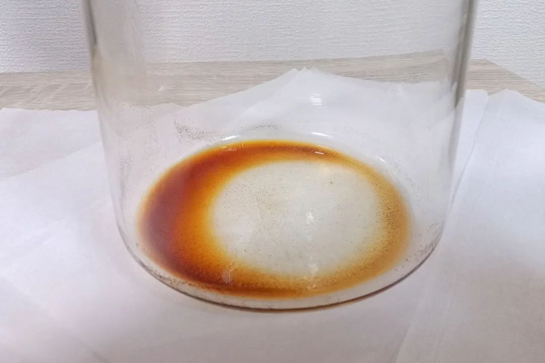 A close up of sediment left behind in a glass carafe after all the cold-brewed coffee has carefully been decanted.