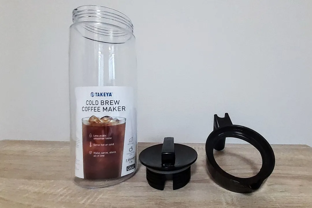 The Tekeya cold brew coffee maker with the user manual inside the decanter, the screw on lid to the right on the countertop.