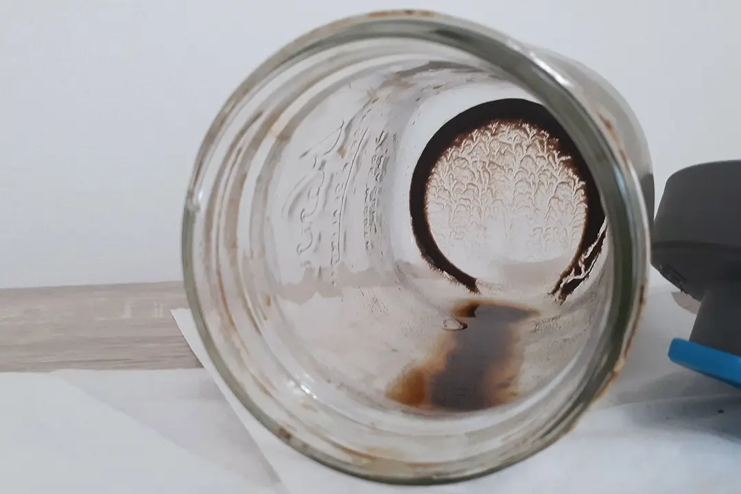 The inside of a cold brew coffee brew carafe showing leftover sediment after all the coffee is carefully decanted. 