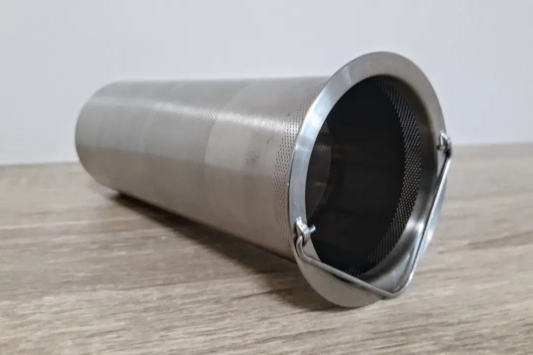 A close up side angle view of a stainless steel brew filter for a cold brew coffee maker.