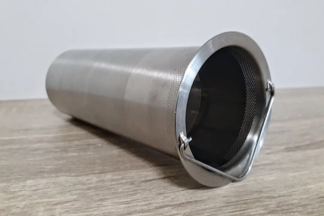 A close up side angle view of a stainless steel brew filter for a cold brew coffee maker.