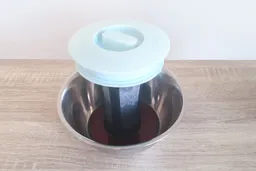 The decanted filter of the Primula cold brew coffee maker standing in a steel bowl to collect coffee run-off.