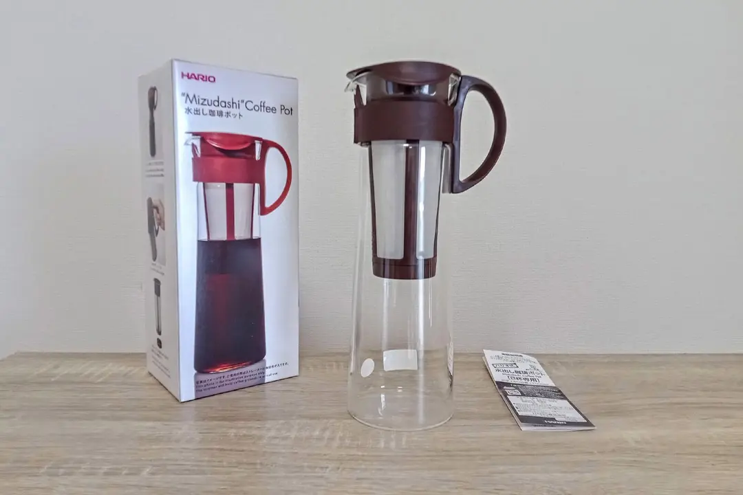 The unboxed Hario Mizudashi cold brew coffee maker with the box to the left and the user guide to the right.