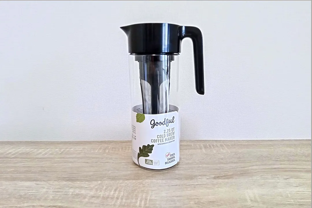 The Goodful cold brew coffee maker with a user guide leaflet rolled up inside.